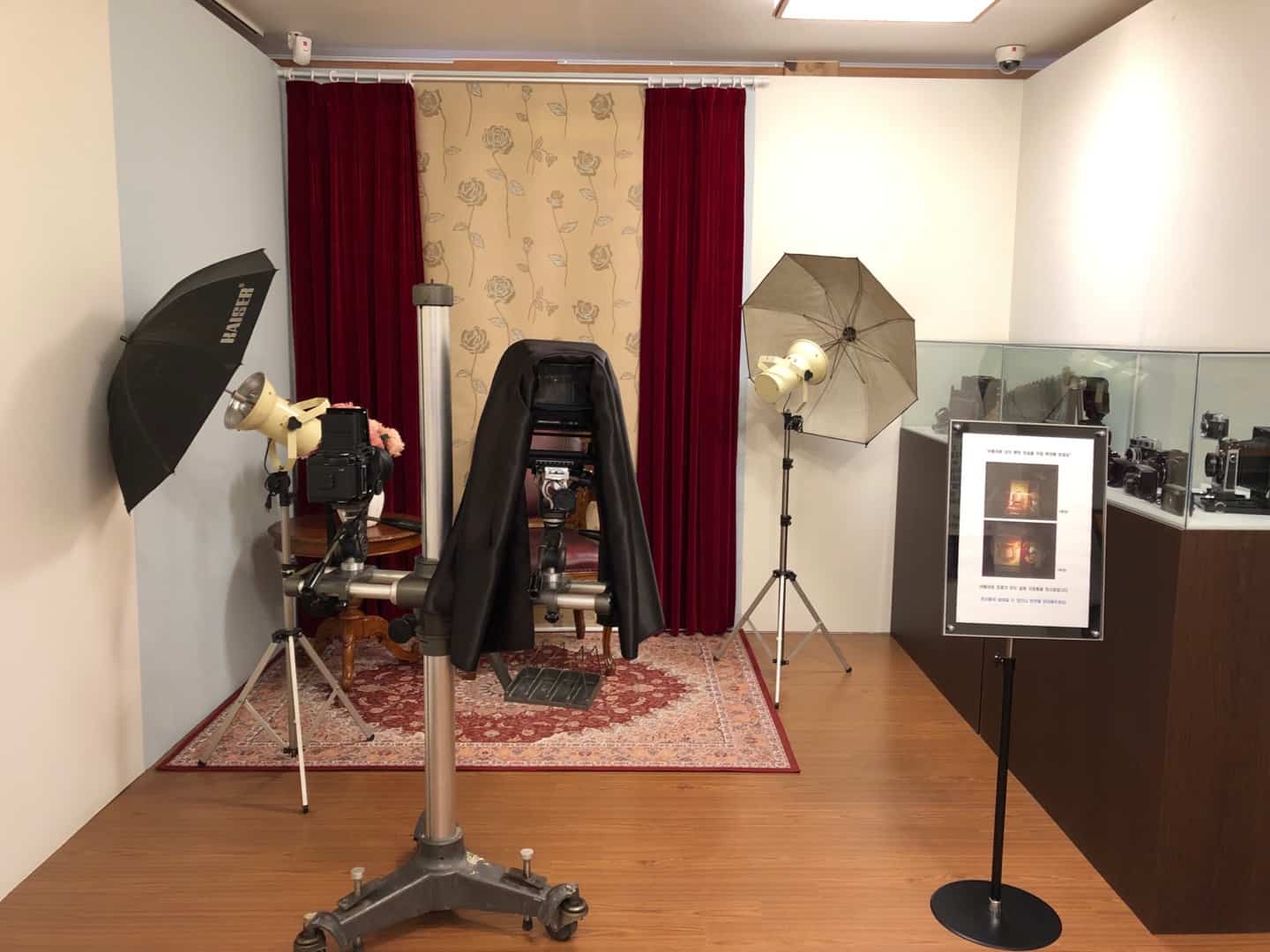 은평한옥마을3 : 카페트와 꽃무늬 커튼으로 장식되어 있고, 조명 장치가 있는 체험관 내 기념 사진 촬영 공간 