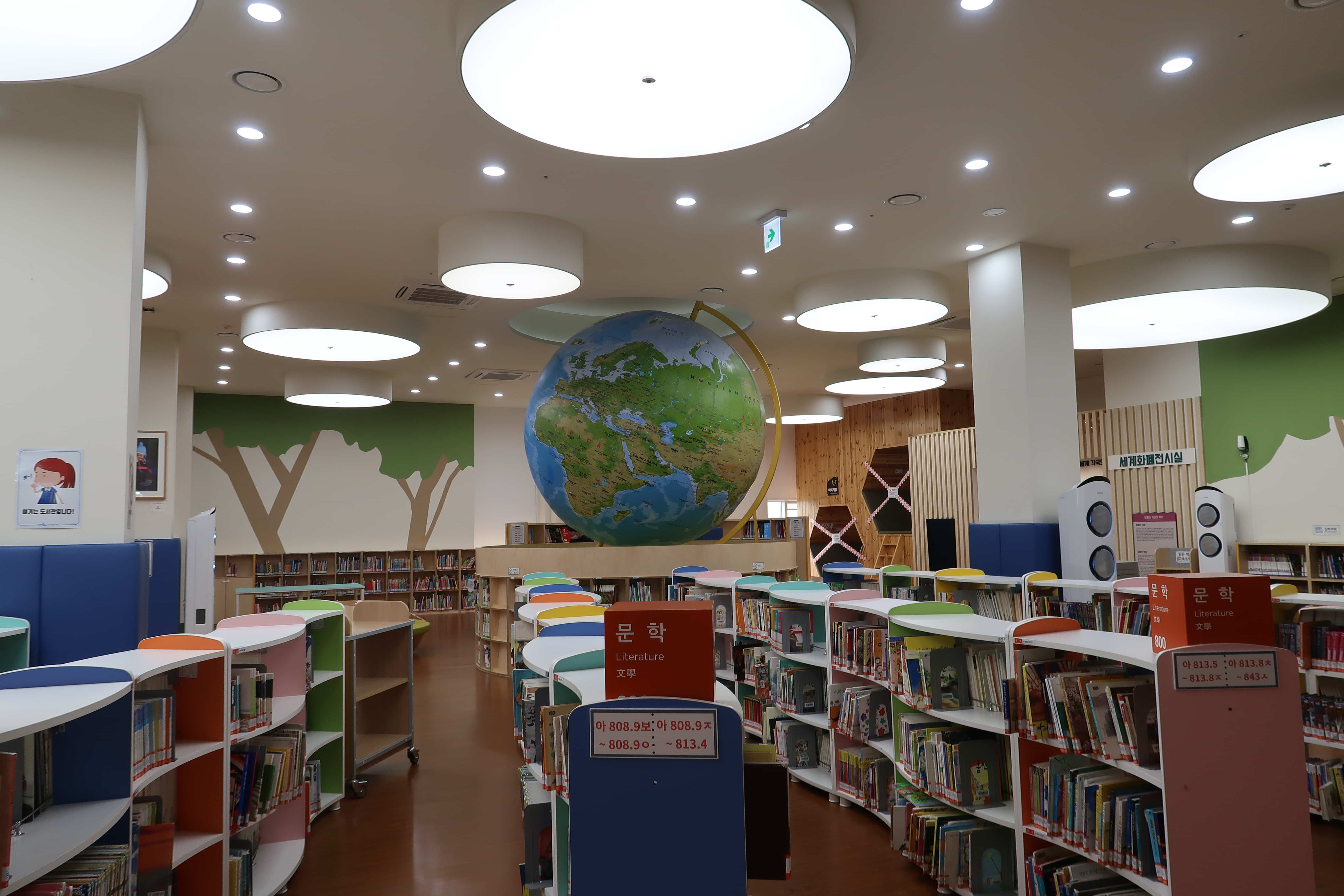 마포중앙도서관0 : 중앙에 큰 지구본이 있고 밝은 조명이 설치된 마포중앙도서관 어린이 열람실 전경