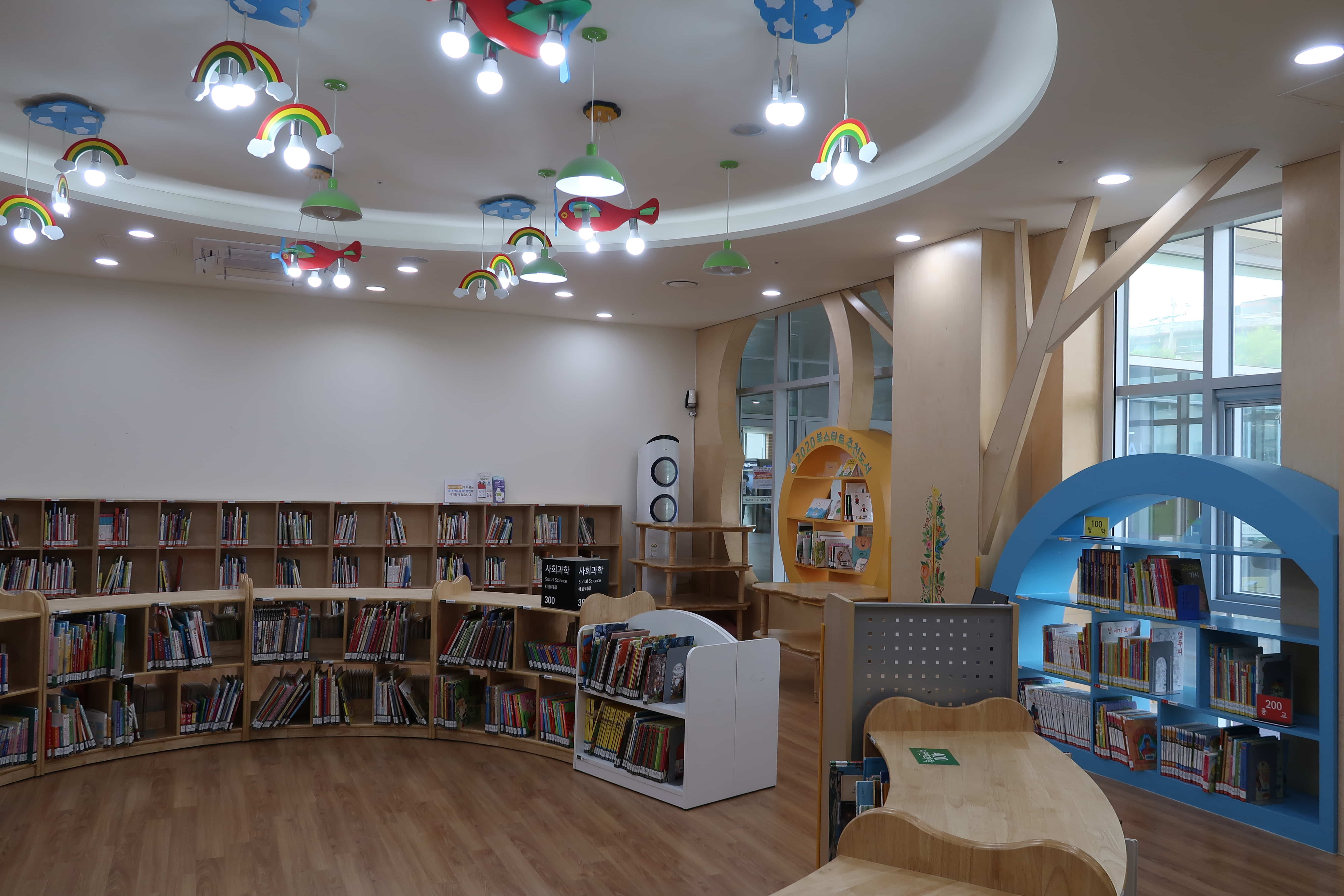 마포중앙도서관1 : 천장에 모빌모양의 밝은 조명이 설치된 마포중앙도서관 어린이열람실 전경
