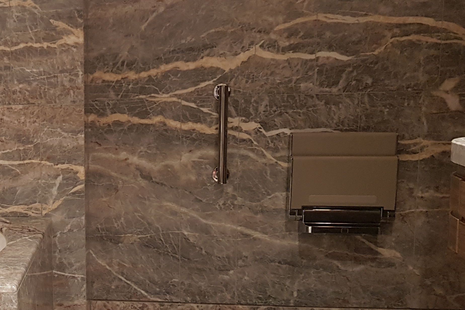 샤워의자0 : 샤워의자가 설치되어 있는 롯데시그니엘 객실 내 화장실 전경