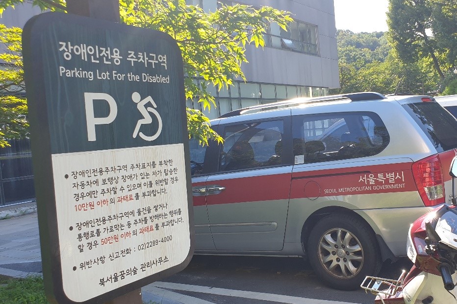 Parking facilities for persons with disabilities0 : A signboard stating the parking zone for the persons with disabilities