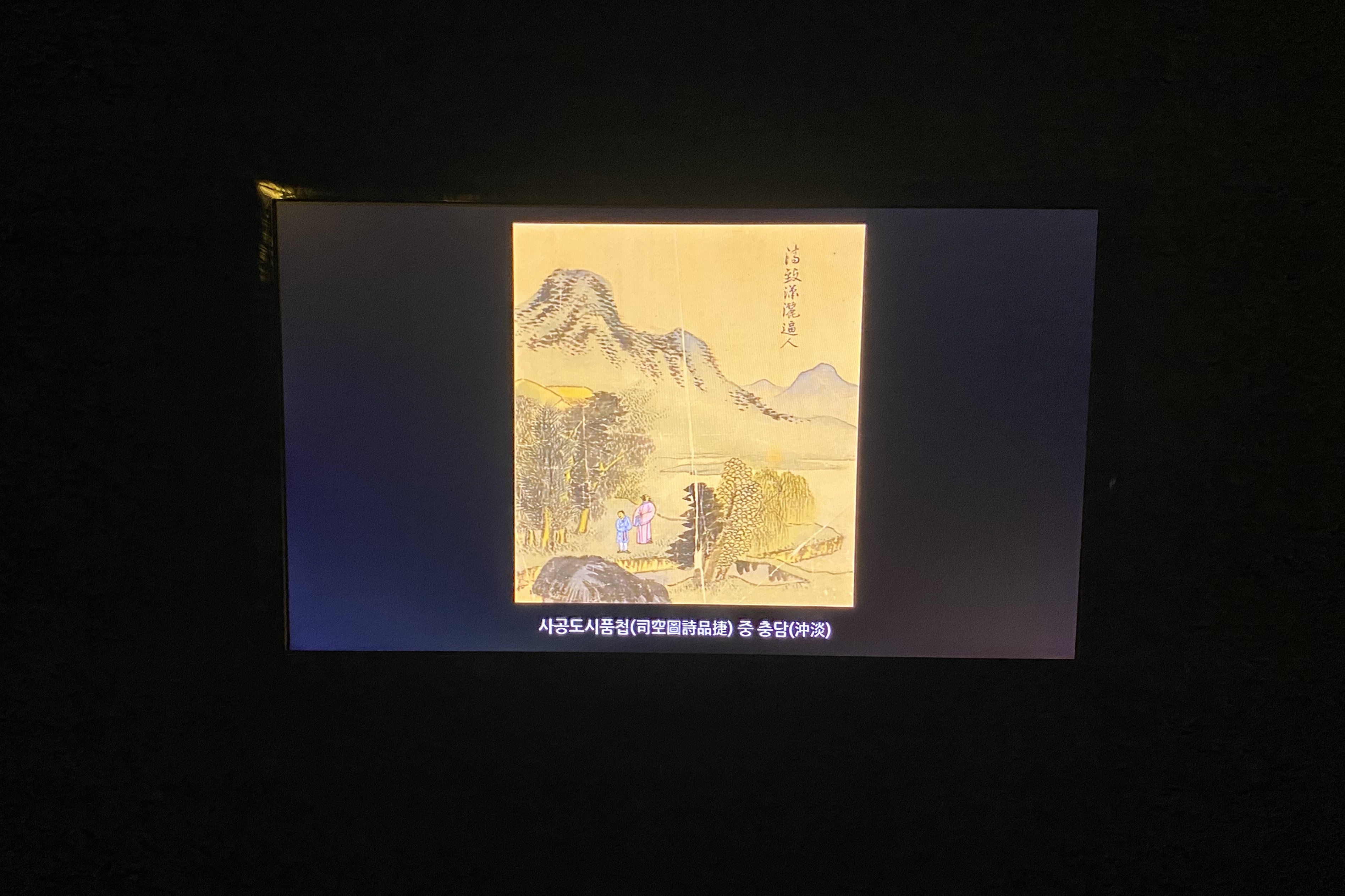 Savina Museum of Contemporary Art4 : A traditional landscape painting with mountains and boatmen displayed on a digital screen
