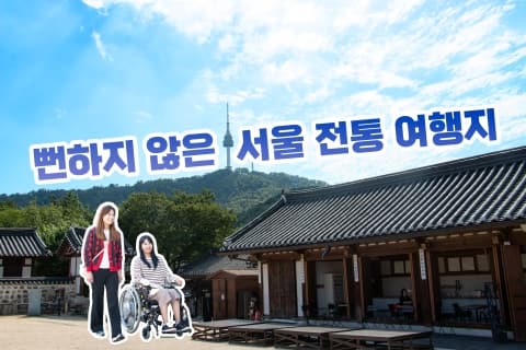 남산골 한옥마을 배경으로 산책을 하는 휠체어 탄 여성과 서있는 여성
