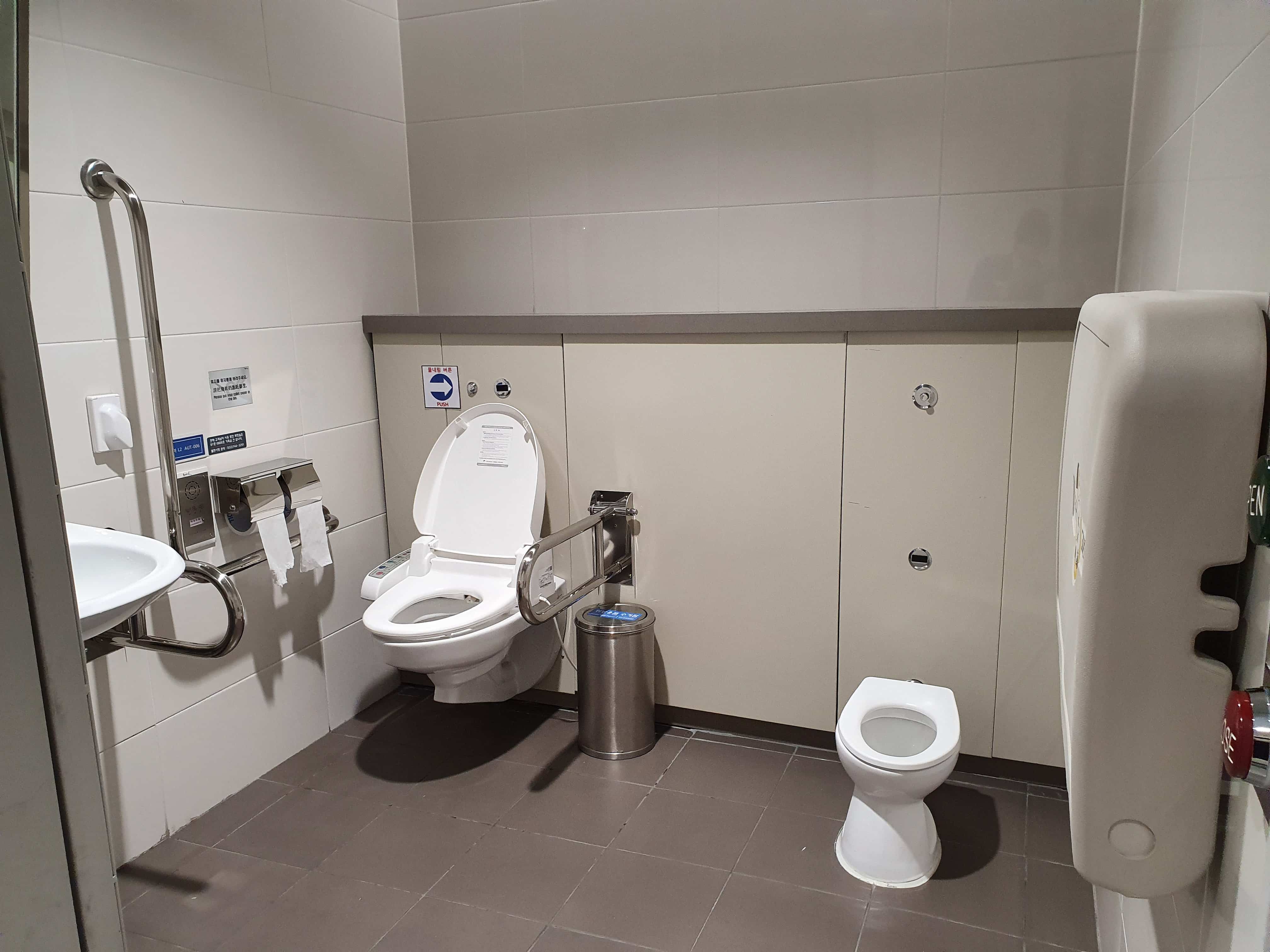 장애인 화장실 0 : 인천국제공항 제2여객터미널 내에 위치한 장애인 화장실 내부 전경. 휠체어 사용자가 편하게 이용할 수 있는 안전바와 기저귀 교환대, 소아용 변기가 있다.
