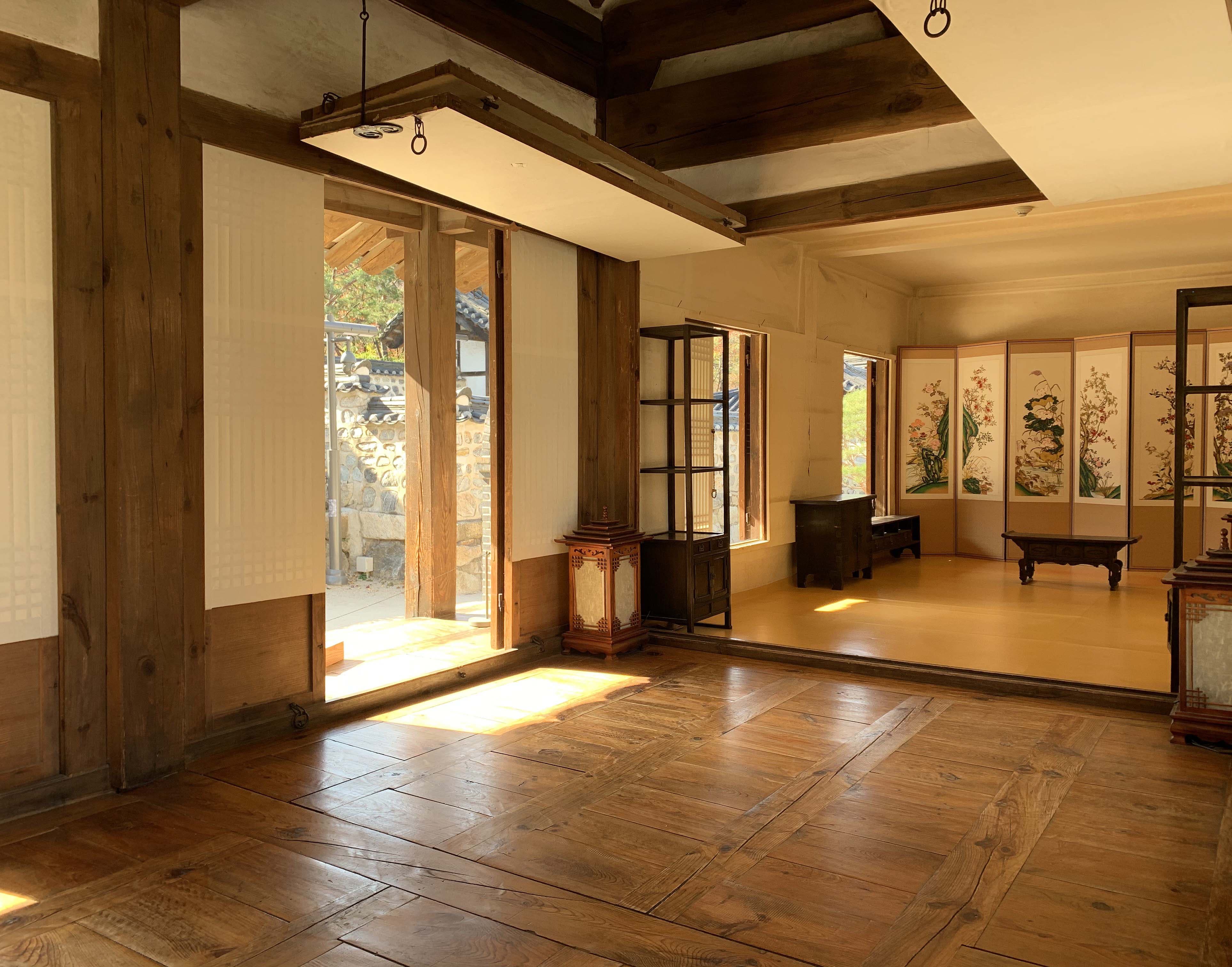 남산골 한옥마을3 : 햇살이 들고 한쪽 벽면에 병풍이 설치된 넓은 전통 가옥 내부