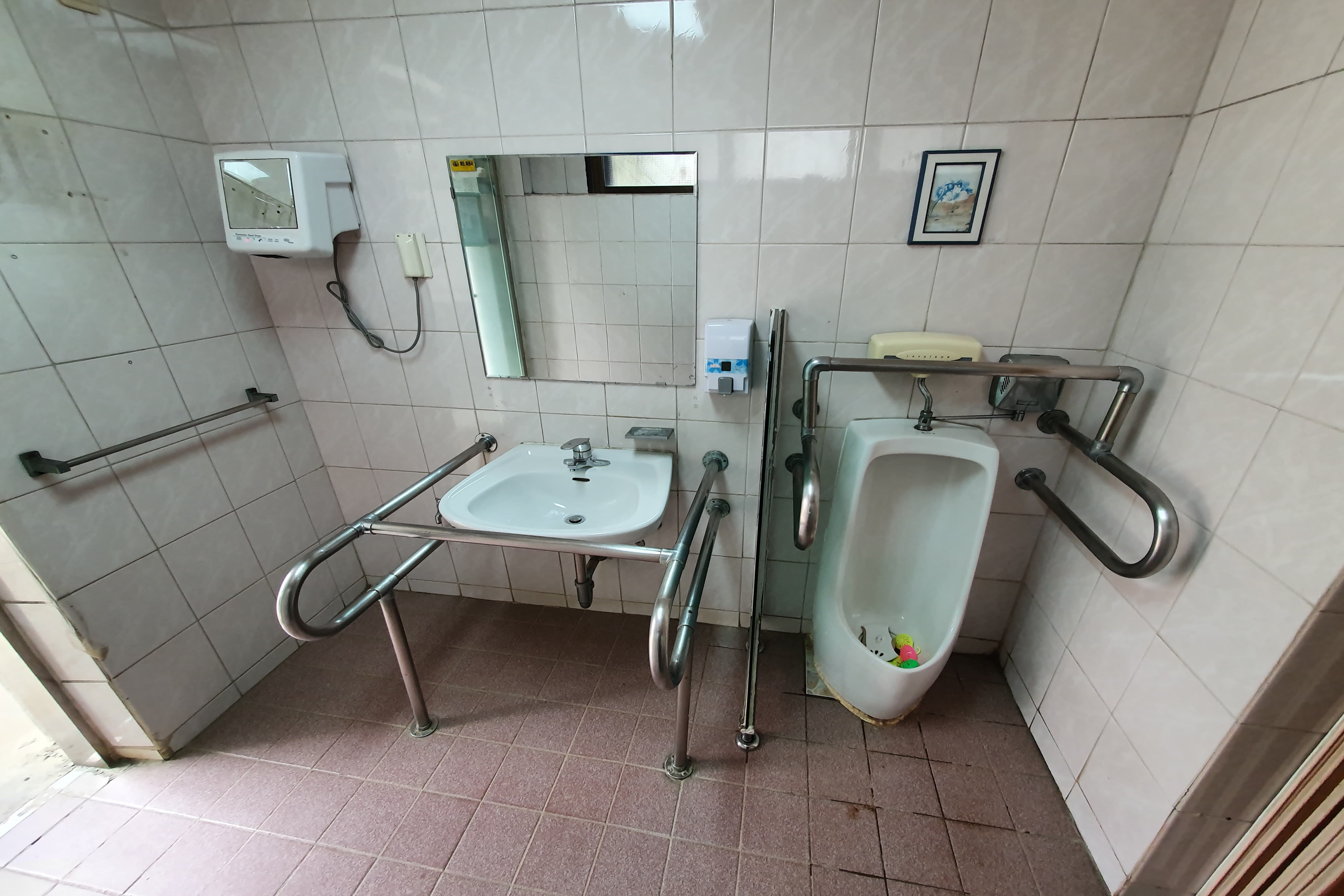 Accessible restroom for persons with disabilities 0 : Accessible toilet with a sink and a urinal side by side