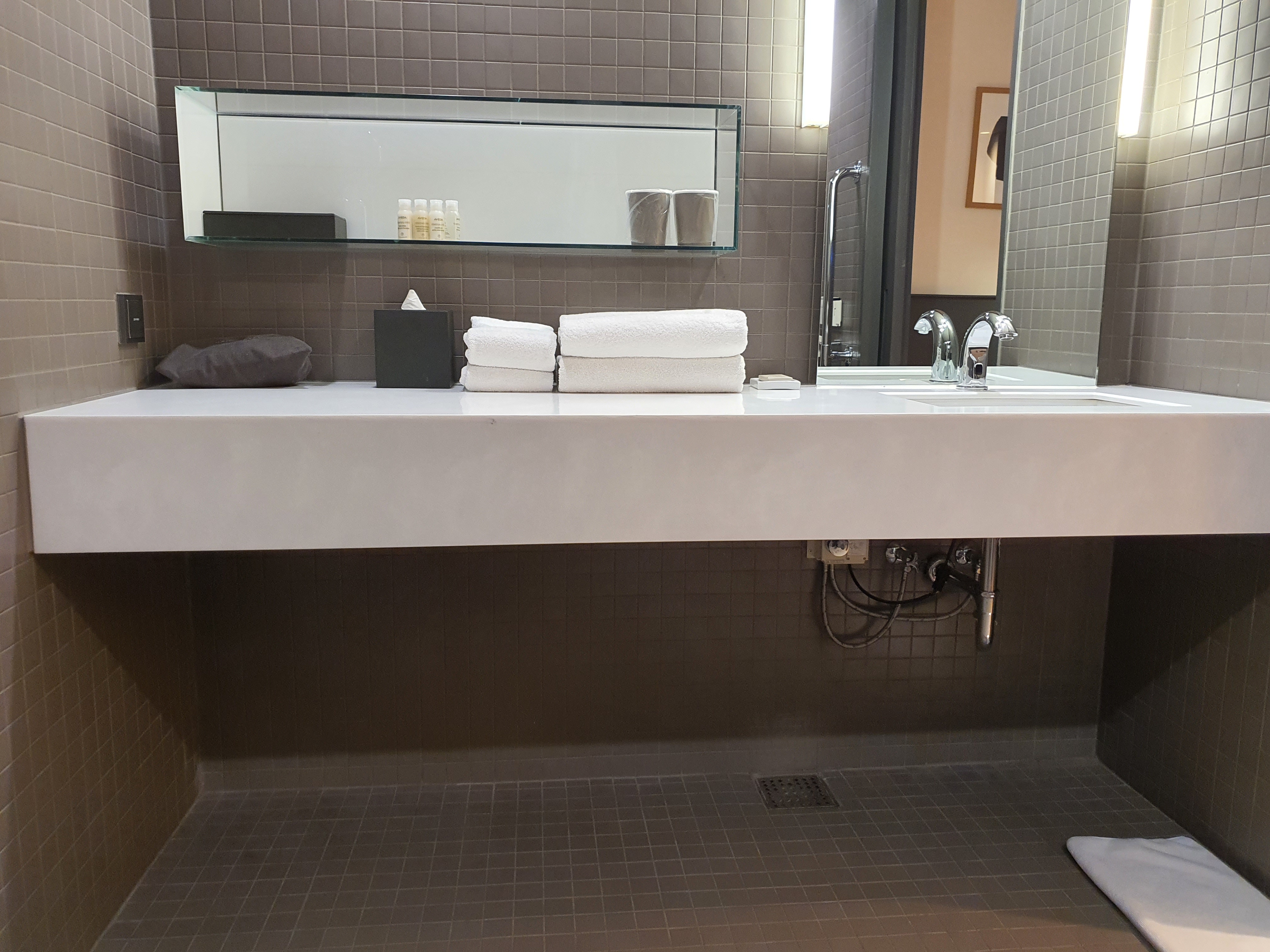 Bathroom in the guestroom 0 : A bathroom sink with a large lower space, taking up the entire wall on one side