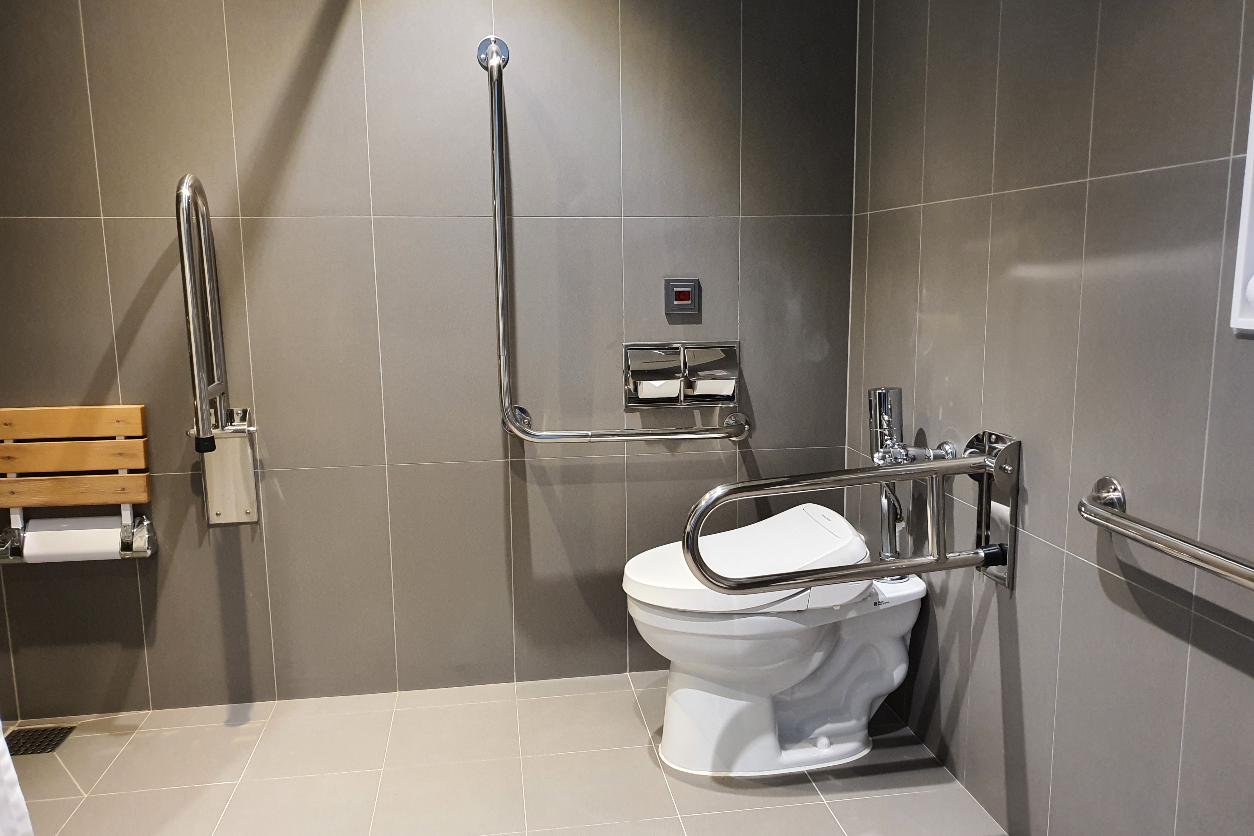 객실 내 화장실0 : 안전 손잡이와 벽걸이형 샤워의자가 설치된 화장실