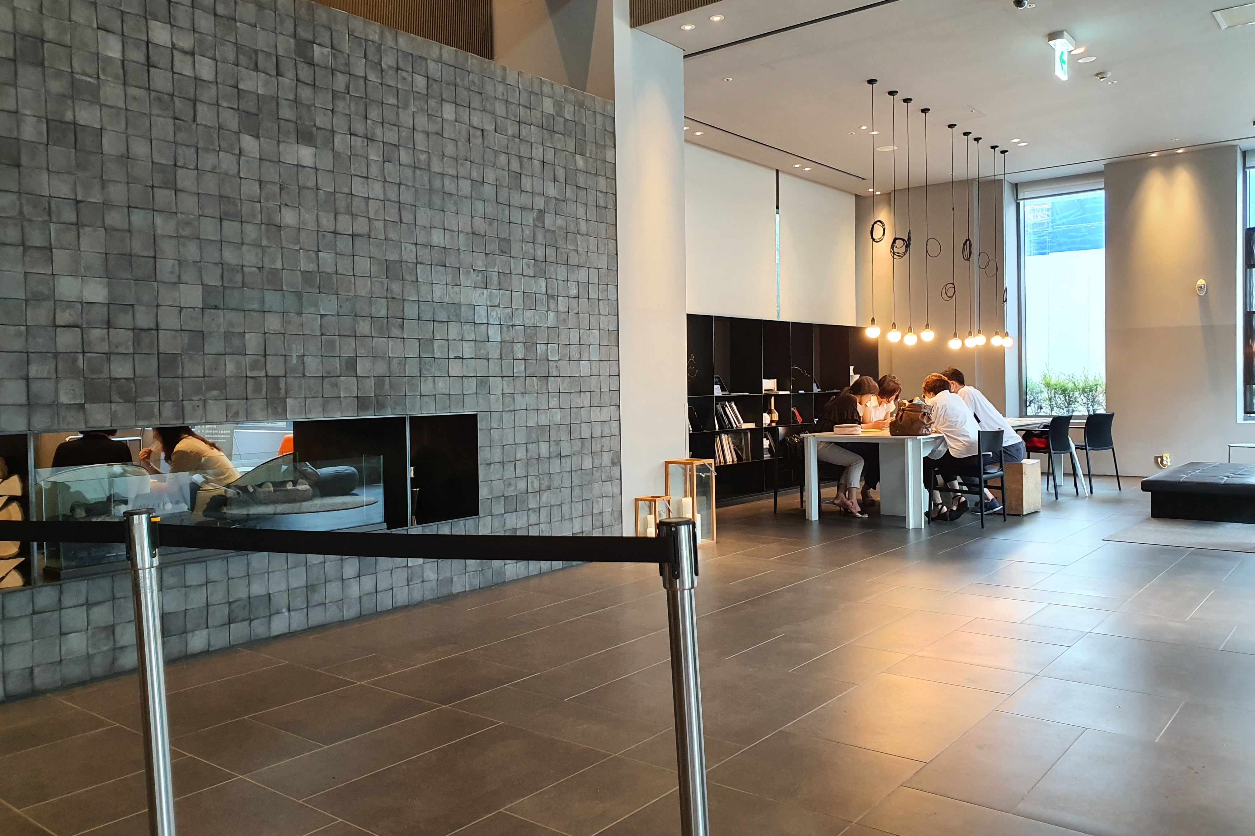 Shilla Stay Seocho2 : A spacious resting area with people sitting around the table at the corner