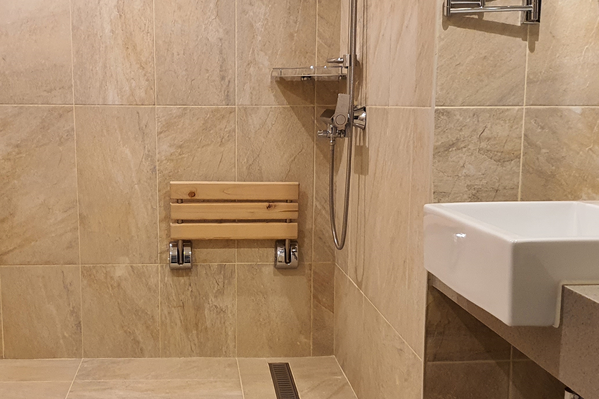 객실 내 화장실0 : 객실 화장실에 설치된 고정식 샤워의자