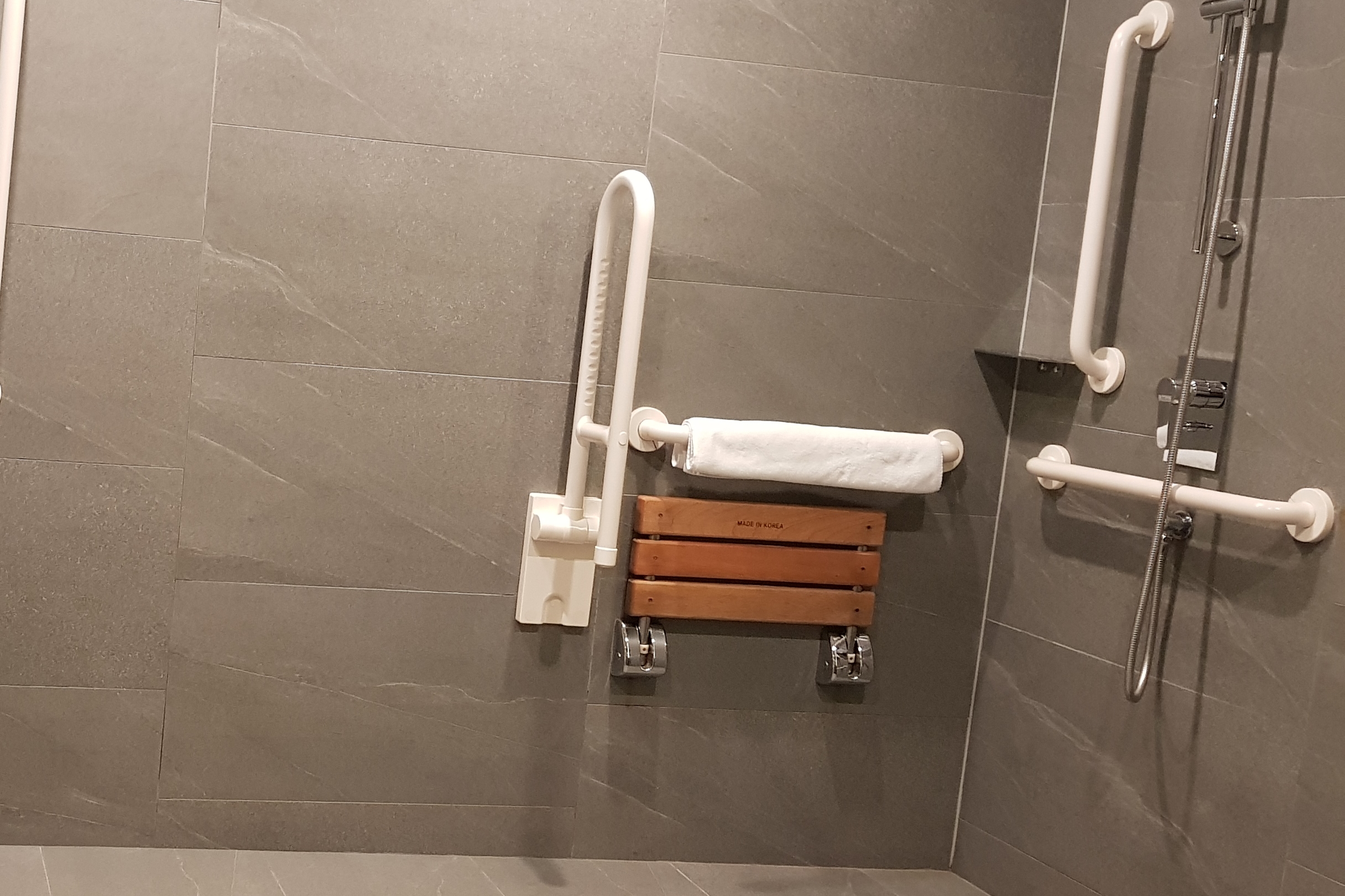 샤워의자0 : 샤워의자가 설치되어 있는 노보텔 앰배서더 서울 동대문 화장실 전경