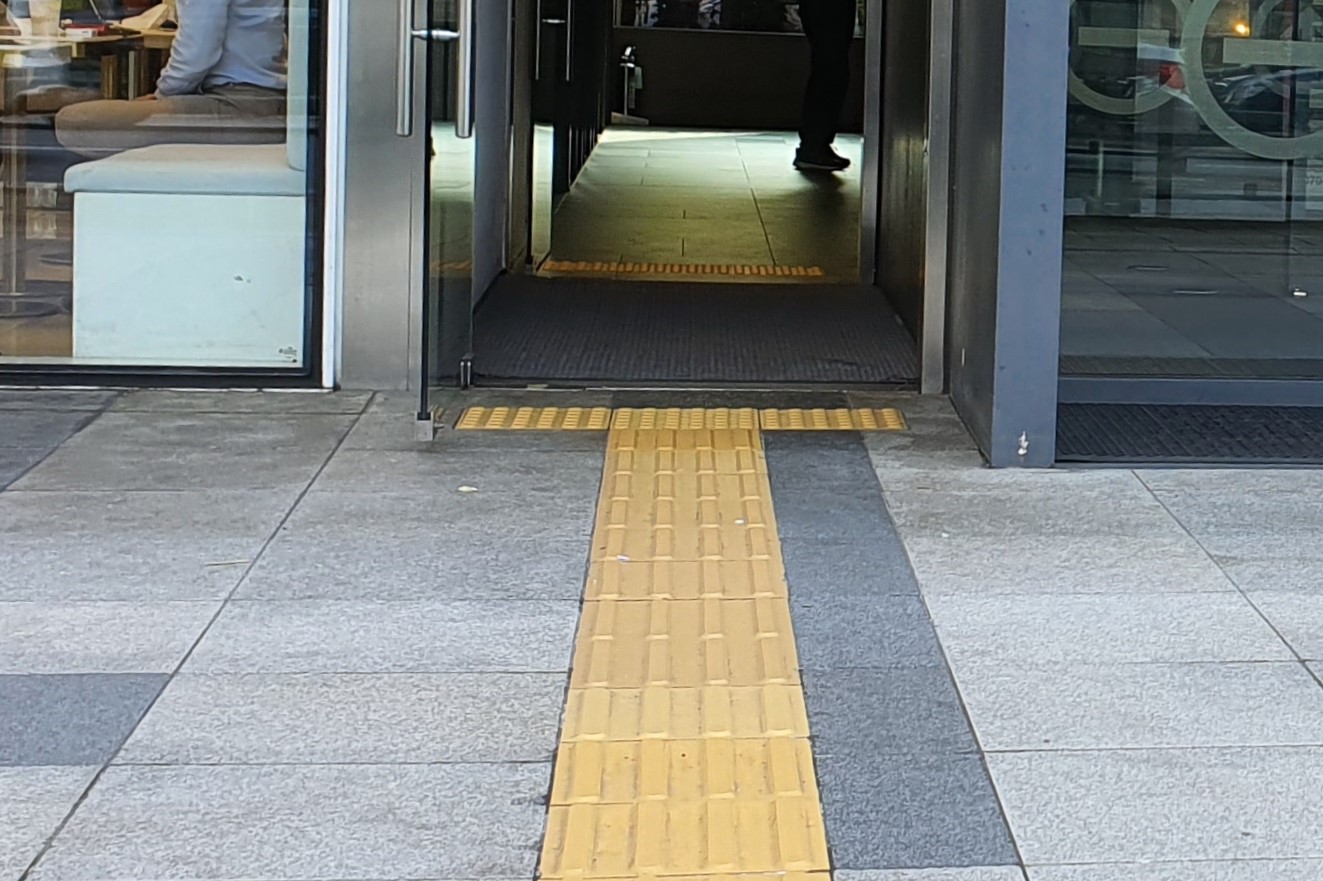 Entryway/Main entrance0 : Tactile paving installed in front of the hinged door of the main entrance