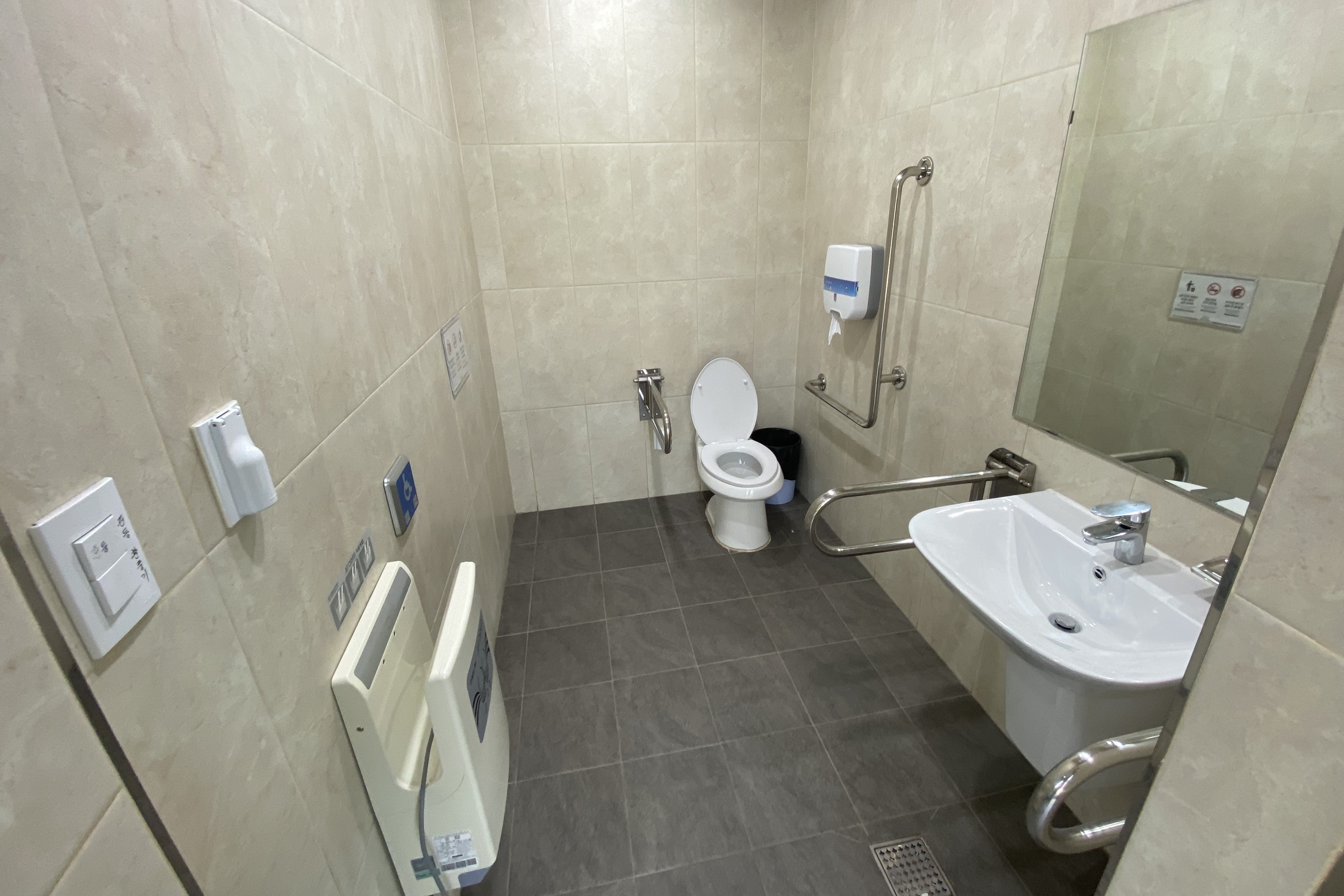 장애인화장실0 : 변기, 세면대, 손 건조기가 설치된 화장실 내부
