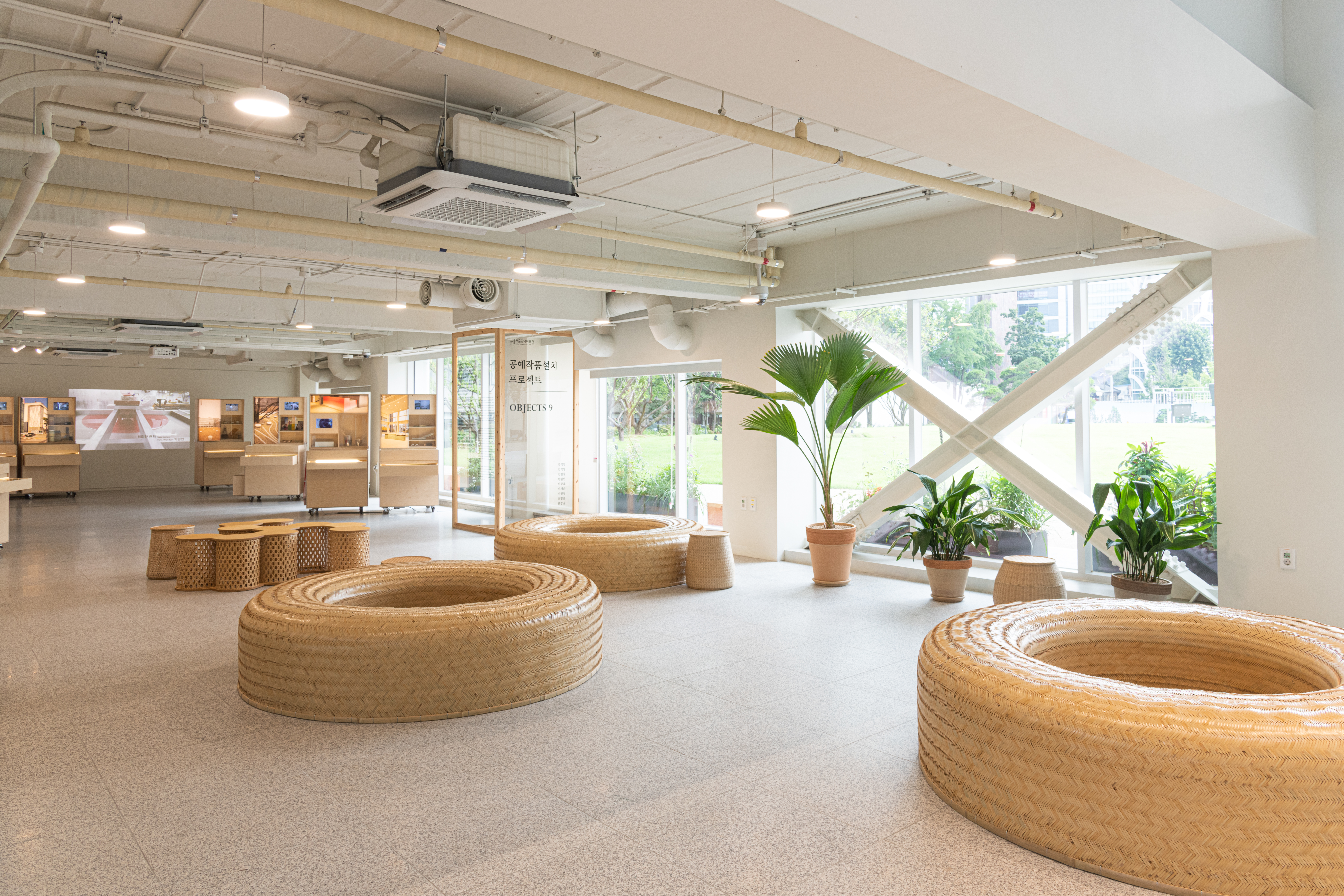 Seoul Museum of Craft Art (SeMoCA)3 : A well-lit relaxing space with several large donut-shaped rattan chairs
