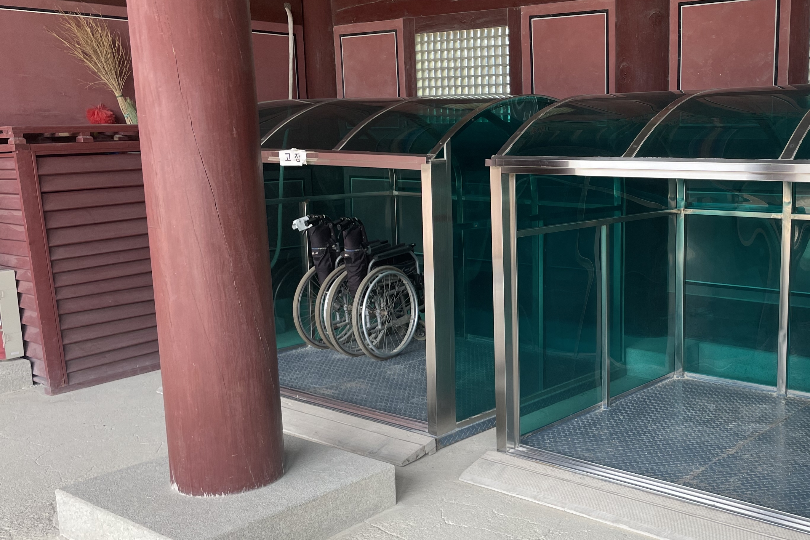 Information board/ Information center0 : Two foldable wheelchairs neatly arranged in a storage with cover
