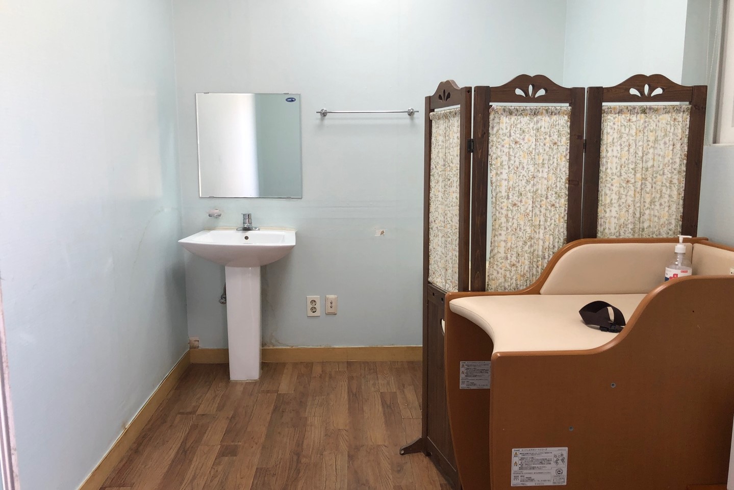 Expecting mothers and children resting area 0 : Inside the nursing room with a partition behind a diaper changing table