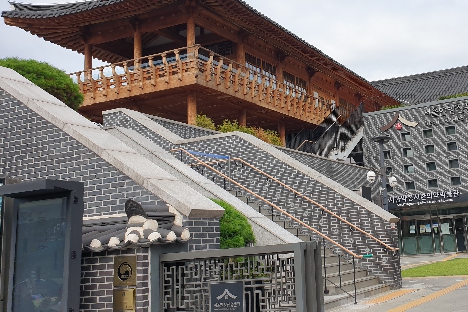 접근로/주출입구0 : 계단위에 한국의 전통 건축 양식으로 건축된 서울한방진흥센터 외관 전경