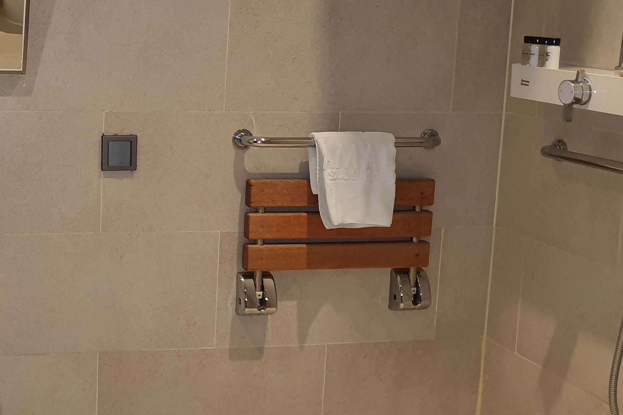 Bathroom in the guest room 0 : A wooden wall-mounted shower chair
