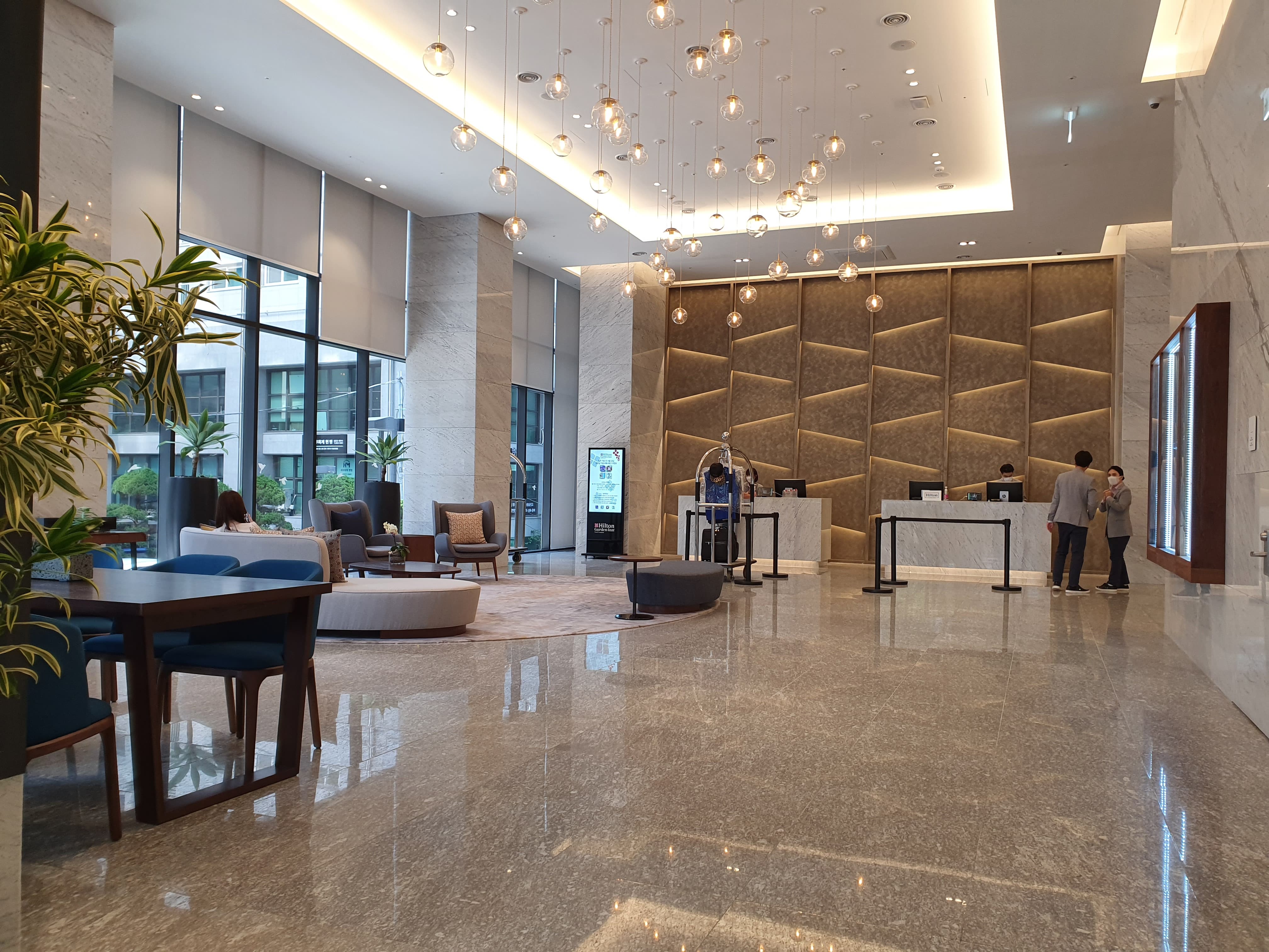 Access Road/ Main Entrance0 : Elegant hotel lobby with high ceilings and lots of lighting