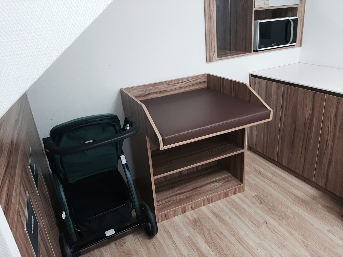 Nursing room 0 : A diaper changing station and a stroller in a nursing room