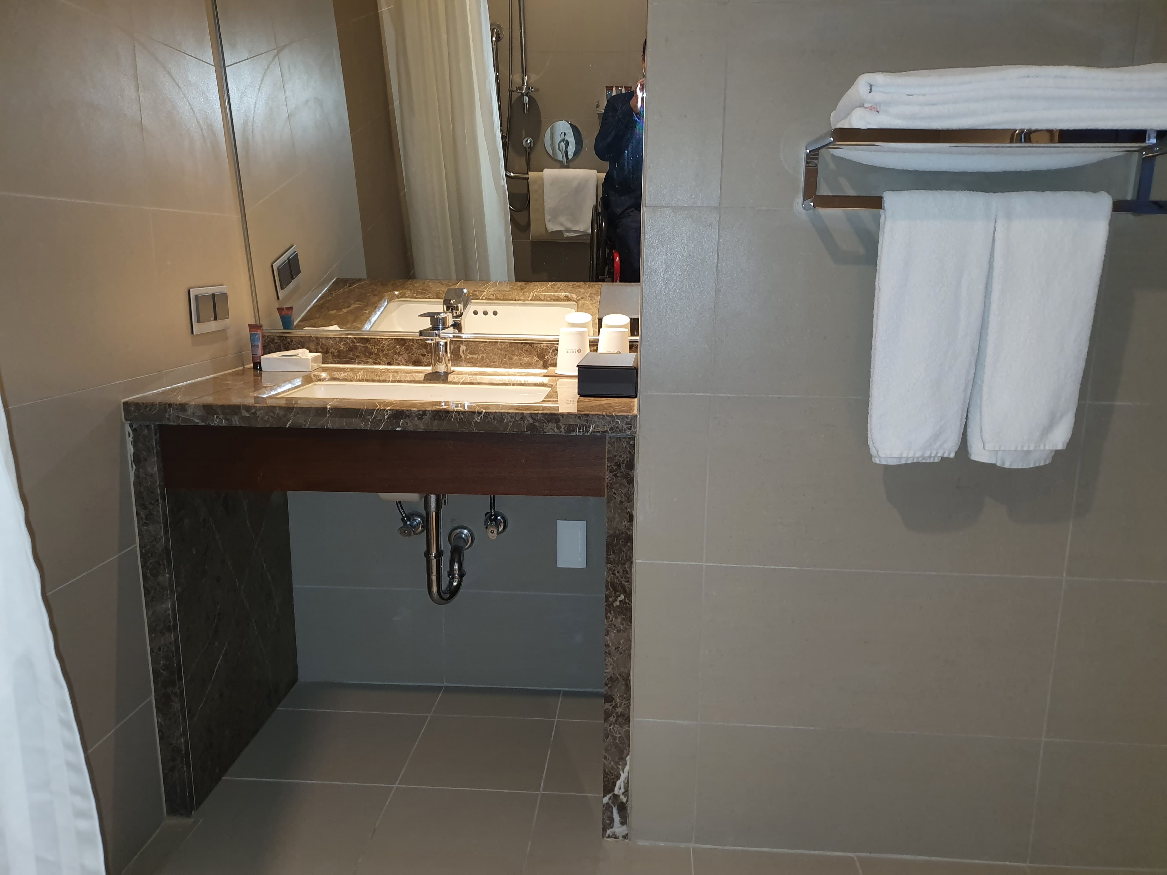 Roll-in shower in the guest room0 : A bathroom sink with large under space
