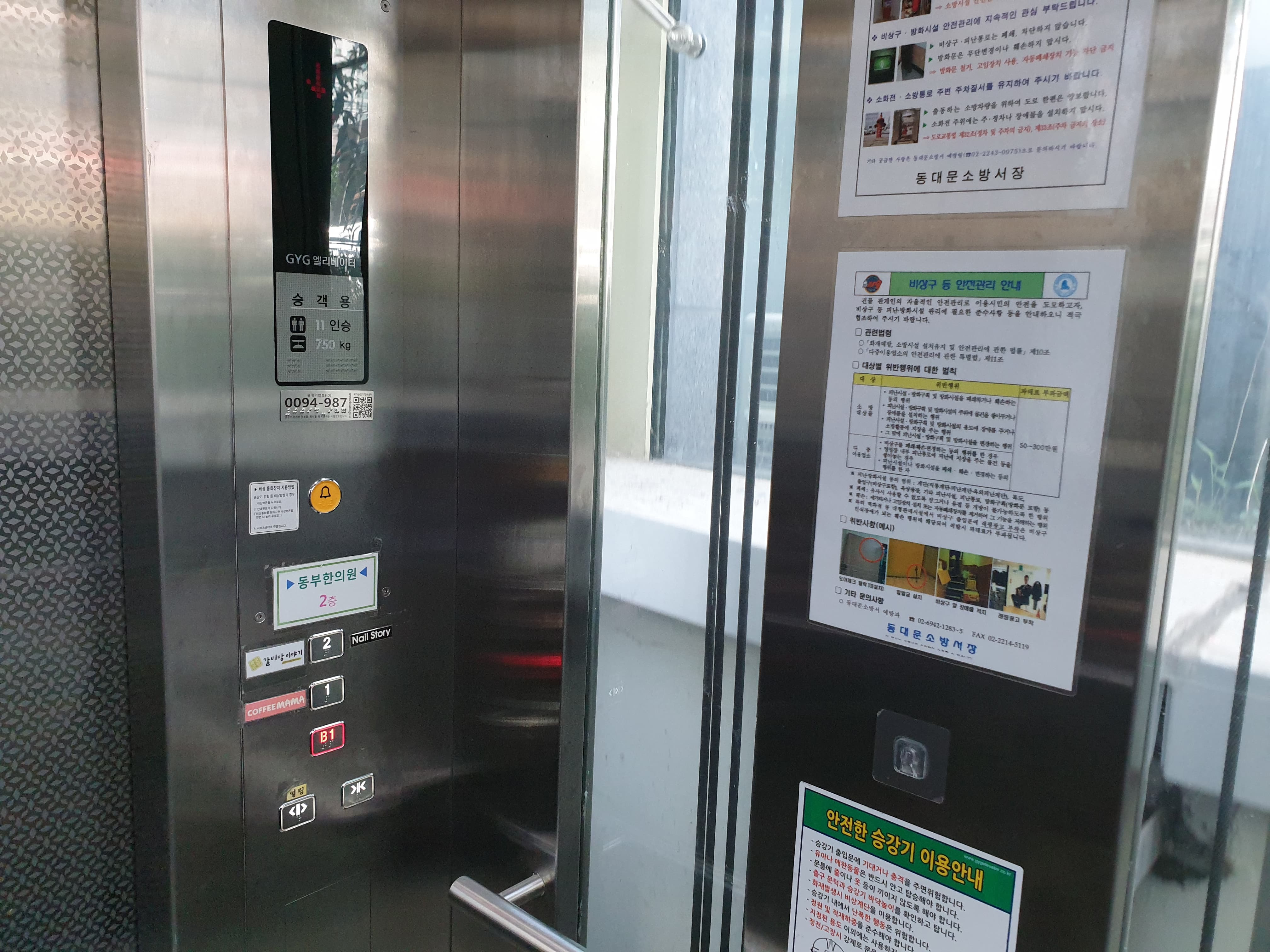 엘리베이터 0 : 시각장애인을 위한 점자 버튼과 비상벨이 설치된 엘리베이터 내부 전경